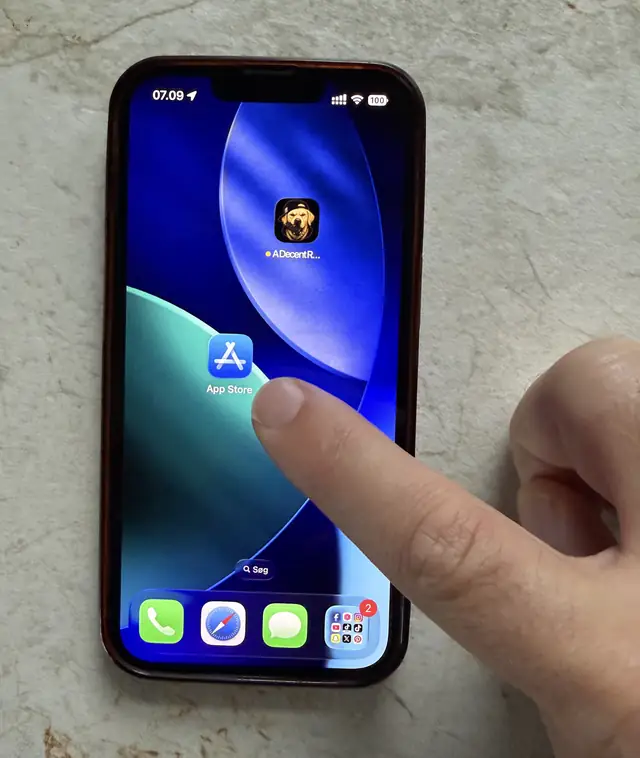 A finger tapping the App Store icon on an iPhone home screen