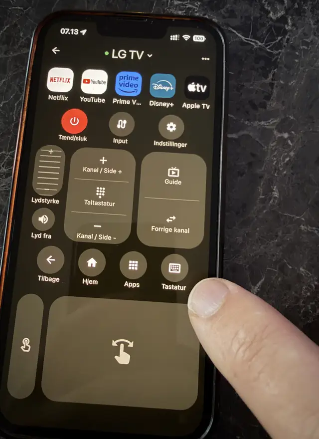 The remote screen in A Decent Remote connected to an LG TV, with a finger on the Keyboard button